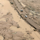 Cars travel on roads that have turned to mud.